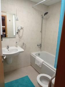 a bathroom with a sink and a tub and a toilet at LOREA Apartment L000 in Aspen Golf Resort in Razlog