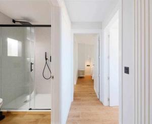 a bathroom with a glass shower and a hallway at Argus San Lorenzo By Silastur in Gijón