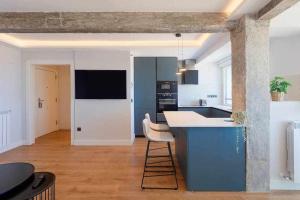 a kitchen with a blue island in a room at Argus San Lorenzo By Silastur in Gijón +23 photos