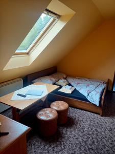 1 dormitorio con 1 cama y 2 taburetes en Penzion Lukáš en Malá Morávka
