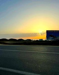 eine leere Autobahn mit Sonnenuntergang im Hintergrund in der Unterkunft Appartement dans résidence à 2 pas de la mer et parking in Tangier