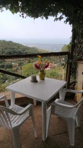 ein weißer Tisch mit zwei Stühlen und ein Tisch mit Blumen darauf in der Unterkunft Casa Vacanza Bel Panorama Collina Versilia in Culla