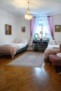 a bedroom with two beds and a table and a chandelier at HoMade B&B, Gamla Stan in Norrköping