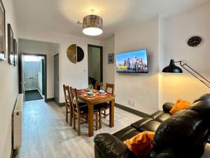 een woonkamer met een bank en een tafel bij Birkin House - Urban Oasis Townhouse in Nottingham