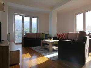 uma sala de estar com um sofá e uma mesa em Big Apartment with private parking - EXTRA VIEW em Skopje