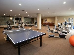 a gym with a ping pong table and chairs at Condo with Lake & Cedar Point Views From Balcony. in Sandusky