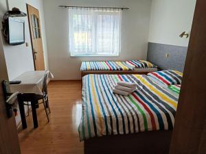 a bedroom with two beds and a table and a window at Rekreačný dom Railip in Trávnica