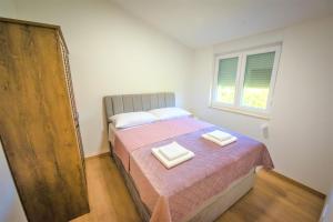 a bedroom with a bed with two towels on it at Holiday Home Marino in Zmijavci