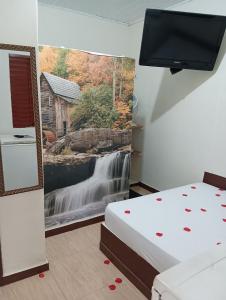 1 dormitorio con un mural de cascada en la pared en Pousada Maravilhas da Serra en Moeda
