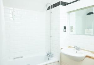 Baño blanco con lavabo y espejo en Fieldhead Hotel by Greene King Inns, en Markfield