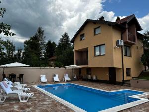 a house with a swimming pool next to a house at Villa Mercurii in Sarajevo