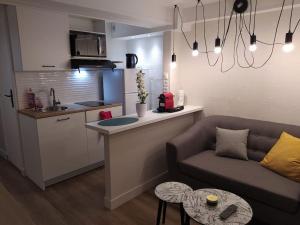 a living room with a couch and a kitchen at Zenitude Place in Margny-lès-Compiègne +9 photos