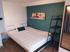 a bedroom with a white bed with a shelf at Zenitude Place in Margny-lès-Compiègne