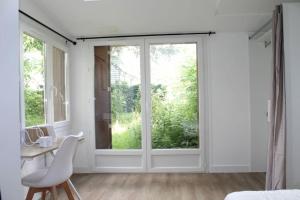 ein Schlafzimmer mit einem Fenster, einem Schreibtisch und einem Stuhl in der Unterkunft Zenitude Place in Margny-lès-Compiègne