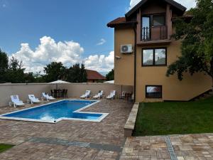 a villa with a swimming pool in front of a house at Villa Mercurii in Sarajevo