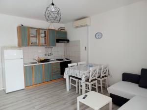 een keuken en een woonkamer met een tafel en een bank bij Apartmani Rameša in Murter