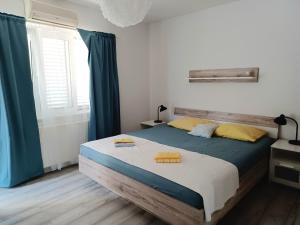 een slaapkamer met een bed met blauwe en gele kussens erop bij Apartmani Rameša in Murter