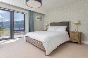 a bedroom with a large bed and a large window at Avernish Lodge-Luxury Self Catering in Kirkton