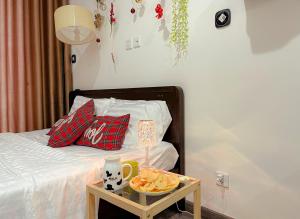 een bed met rode kussens en een dienblad met eten bij Monday Homestay -R103 Vinhomes Ocean Park-Gia Lam-Ha Noi in Gia Lâm Pho