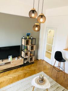 a living room with a television and a table at Lovely apartment in the heart of the city center in Bucharest