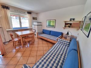 a living room with a blue couch and a table at NEGRITELLA in Alba di Canazei