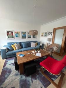 een woonkamer met een blauwe bank en een houten tafel bij Wave - Beach House, Baleal in Baleal