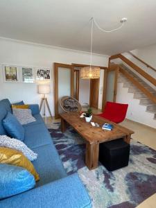 een woonkamer met een blauwe bank en een houten tafel bij Wave - Beach House, Baleal in Baleal
