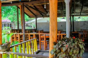 a restaurant with wooden tables and chairs and a table at Sigiri Nirwana Lodge in Sigiriya