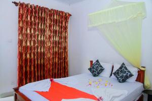 a bedroom with a bed with a red curtain at Sigiri Nirwana Lodge in Sigiriya