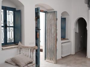 Habitación con puerta de madera y ventana en Dar Ennour Djerbahood Erriadh en Houmt El Souk