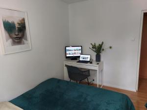 a bedroom with a desk with a computer on it at Arco - near MERTO, PARK in Warsaw