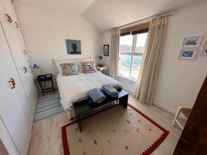 1 dormitorio con cama y ventana grande en Spectacular views Simonstown, en Ciudad del Cabo