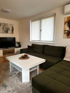 a living room with a couch and a table at Villa Mercurii in Sarajevo