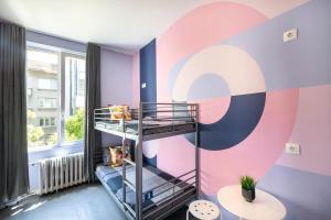 ソフィアにあるBla Bla Hostelのカラフルな壁の客室で、二段ベッドが備わります。