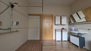 a bathroom with a shower and a sink and a refrigerator at Pension am Park in Pforzheim
