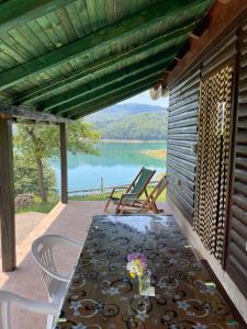 a table and chairs on a patio with a view of a lake at Vikendica Jagoš in Mitrovac