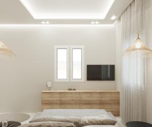 a bedroom with a bed and a tv on a wall at Poema Antiparos in Antiparos
