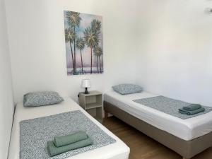 two beds in a room with a painting on the wall at MINT Novalja Apartments in Novalja