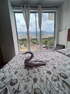 - une chambre avec une grande fenêtre et un serpent sur un lit dans l'établissement Apartamentos Turísticos OASIS, à San Jerónimo