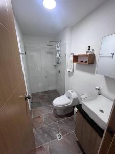 La salle de bains est pourvue de toilettes, d'un lavabo et d'une douche. dans l'établissement Apartamentos Turísticos OASIS, à San Jerónimo