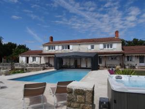 a swimming pool in front of a house at les gîtes de La Cossais in Saint-Cyr-en-Talmondais