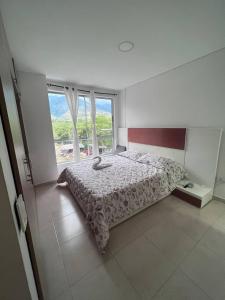 - une chambre avec un lit et une grande fenêtre dans l'établissement Apartamentos Turísticos OASIS, à San Jerónimo
