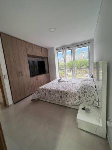 - une chambre avec un lit et une grande fenêtre dans l'établissement Apartamentos Turísticos OASIS, à San Jerónimo