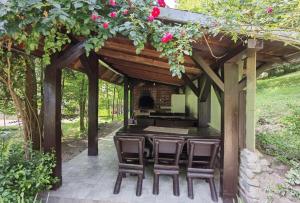 a patio with a table and chairs under a pergola at Craita in Căpăţîneni-Ungureni