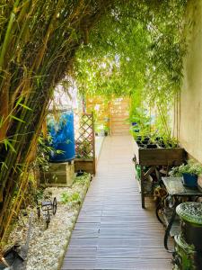 einem Torbogen mit Pflanzen und Bänken in einem Garten in der Unterkunft Studio indépendant de 25m2 in Vitry-sur-Seine