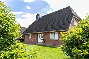 a red brick house with a black roof at Ferienwohnung Meeressand in Sankt Peter-Ording