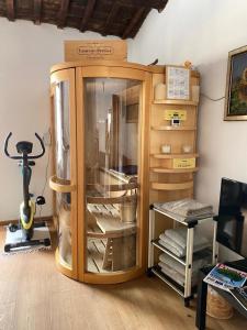 a wooden cabinet with a glass door in a room at San Marino Skyline - Suite Olimpio in San Marino