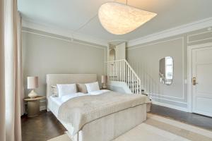 a white bedroom with a bed and a staircase at Stylish Spacious Flat w 3BR in Copenhagen City in Copenhagen