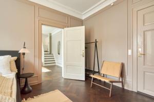 een slaapkamer met een bed, een stoel en een spiegel bij Stylish Spacious Flat w 3BR in Copenhagen City in Kopenhagen