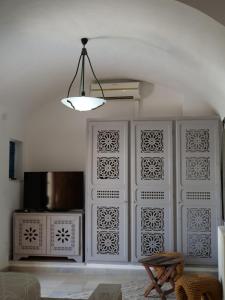 a room with a white wall with a chandelier at Dar Ennour Djerbahood Erriadh in Houmt Souk